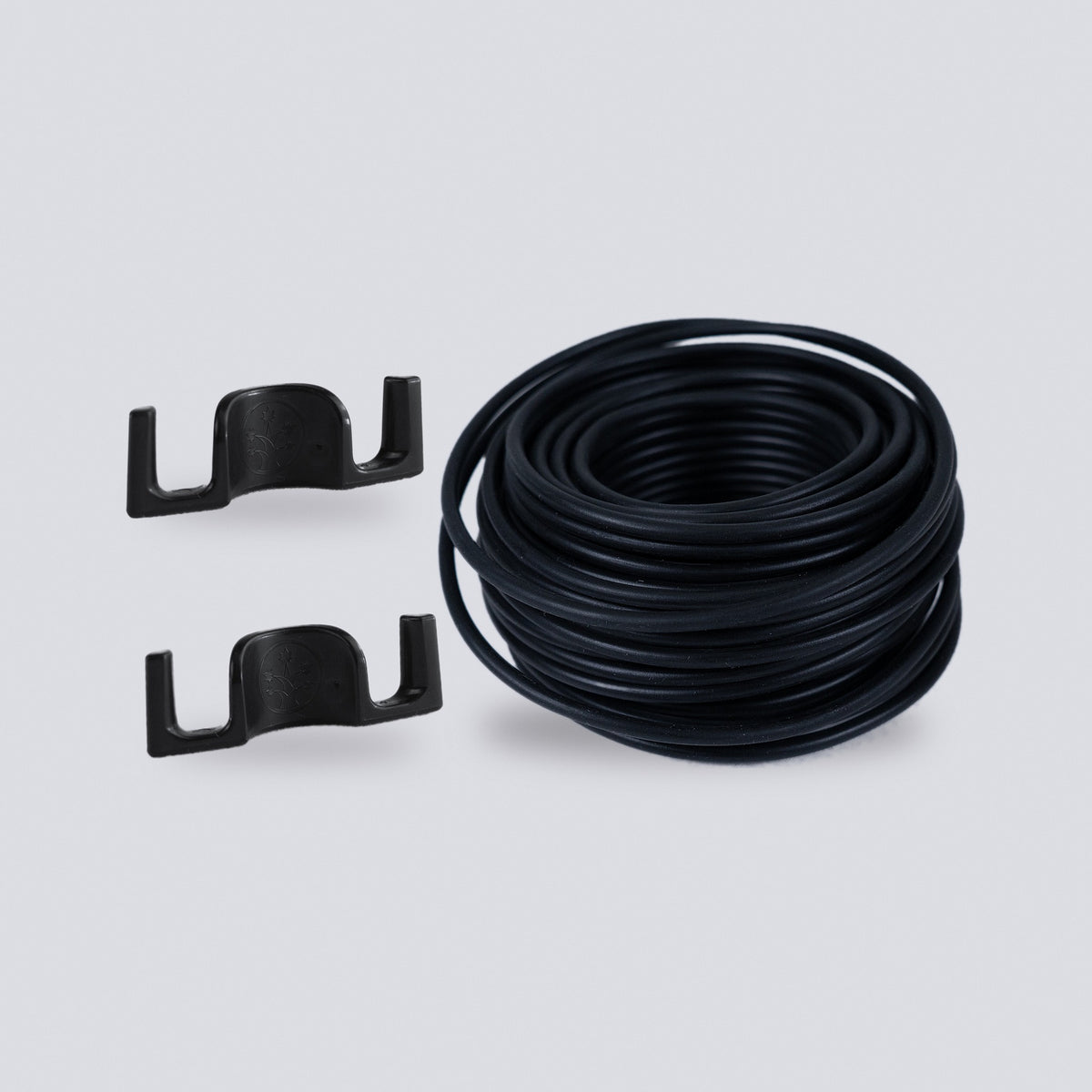 Black plant training clips and a coil of black soft garden wire on a grey background