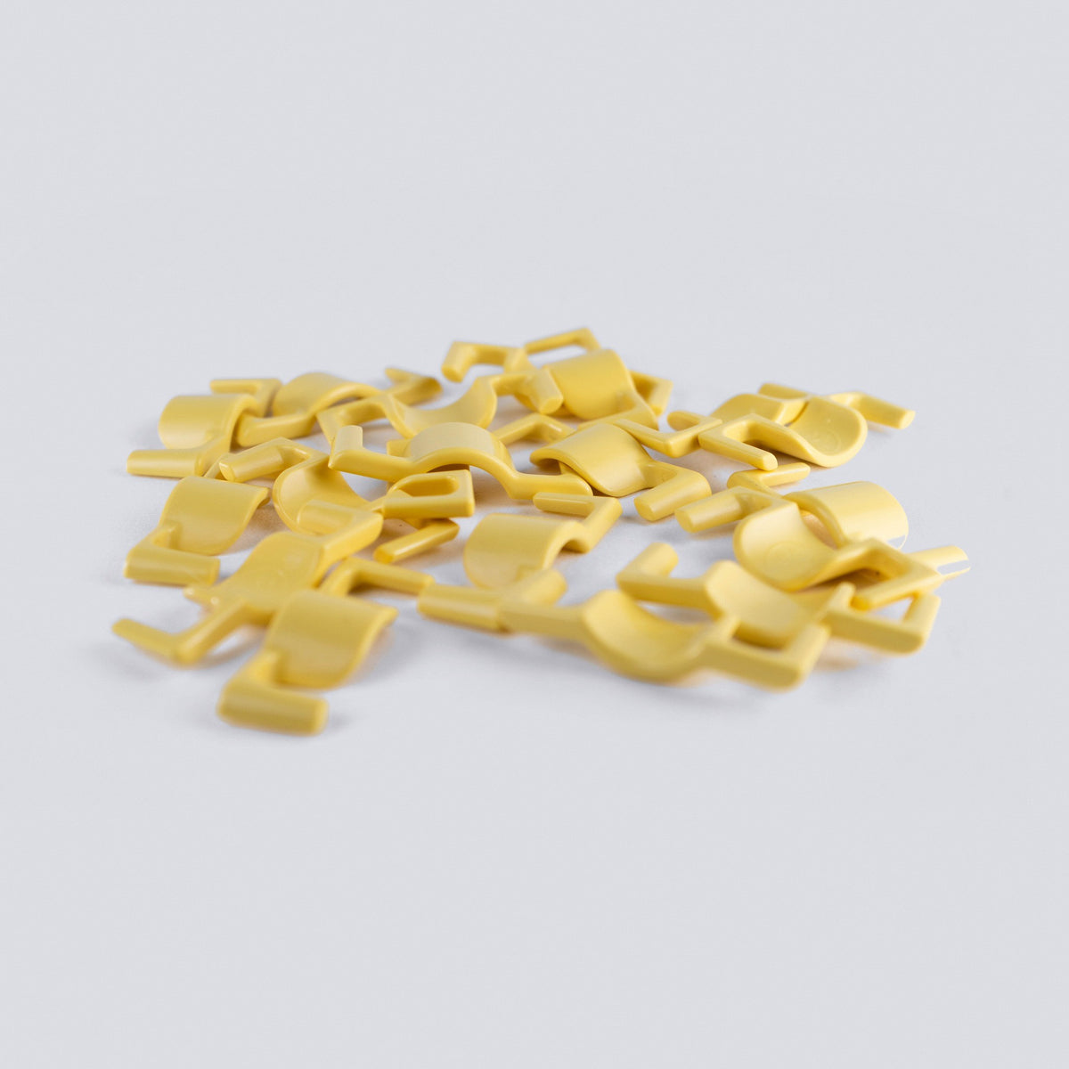 Yellow plant training clips on a grey background
