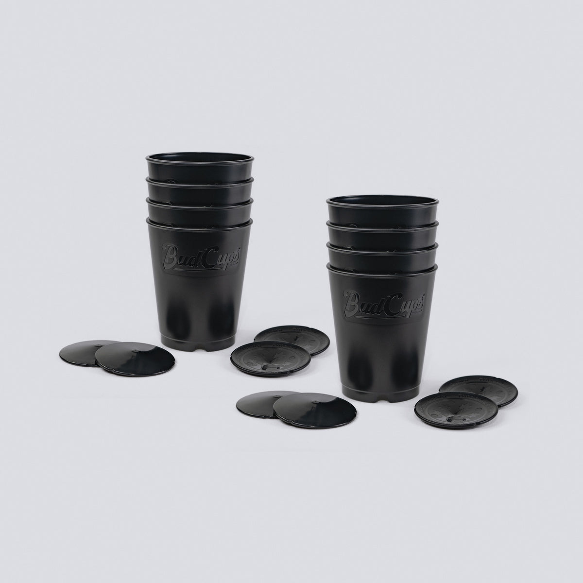 Two stacks of black seed starting cups with their bottom plates, ten cups in all