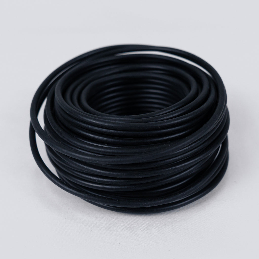 Coil of black soft garden wire on a grey background