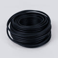 Coil of black soft garden wire on a grey background